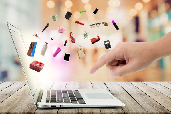ecommerce shopping cart ashop online shopping products coming out of laptop hand pointing at laptop keyboard